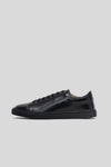 Side profile studio view of the Olen Città low-top sneaker in black calfskin leather with neutral tan lining.