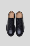 Top-down studio view of a pair of Olen Città low-top sneakers in black calfskin leather with neutral tan lining.