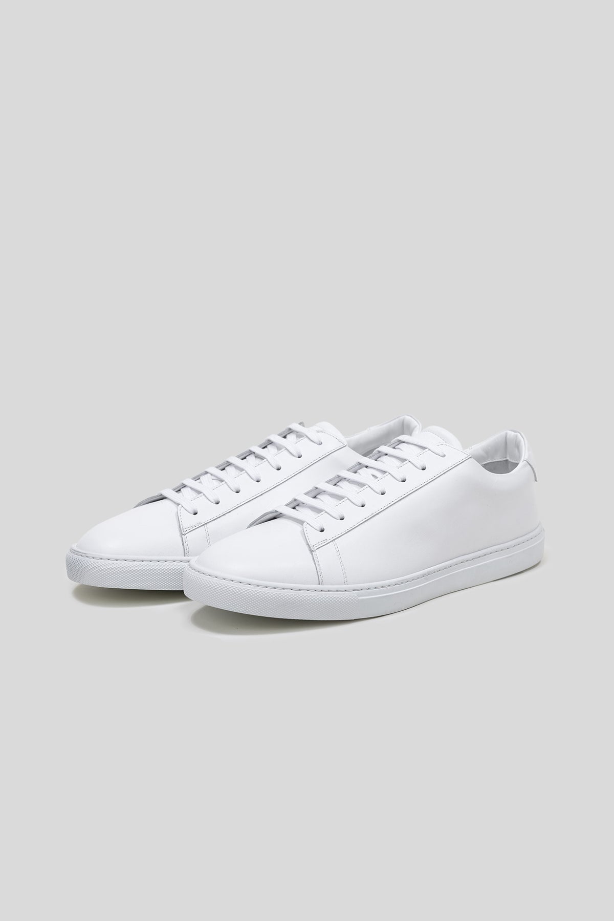 White Calfskin Città Sneaker, pair shown at an angle, minimalist low-top with white calfskin upper and matching sole
