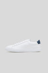 Side profile studio view of the Olen Città low-top sneaker in white calfskin leather with a navy heel tab.