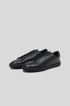Three-quarter studio view of a pair of Olen Città low-top sneakers in black calfskin leather.