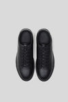Top-down studio view of a pair of Olen Città low-top sneakers in black calfskin leather.