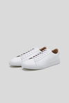 Three-quarter studio view of a pair of Olen Città low-top sneakers in white calfskin leather with neutral tan lining.