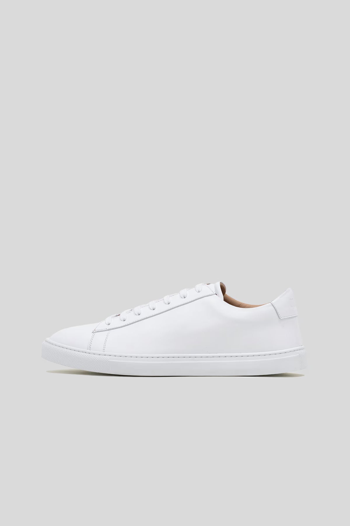Side profile studio view of the Olen Città low-top sneaker in white calfskin leather with neutral tan lining.