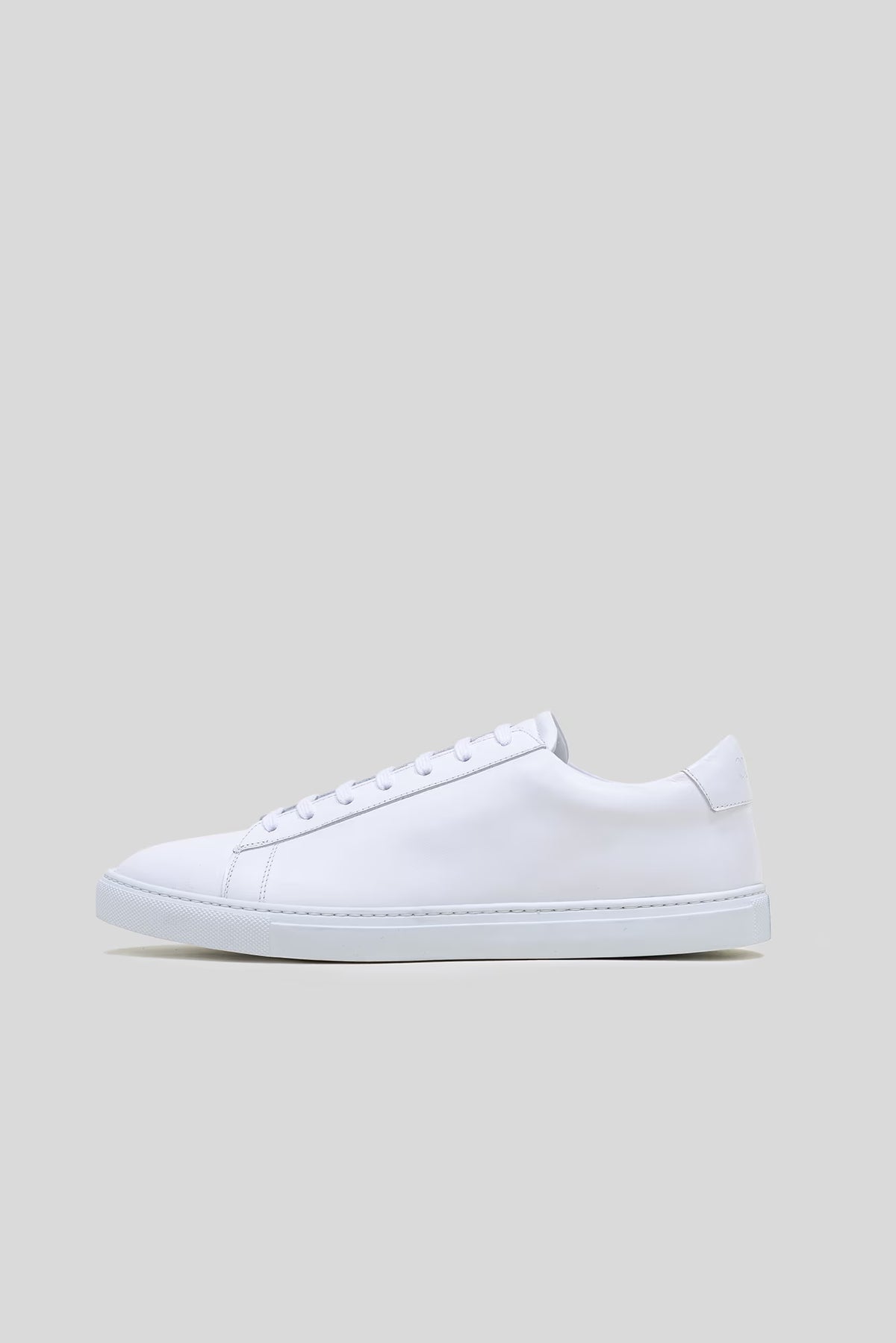 Side profile studio view of the Olen Città low-top sneaker in white calfskin leather.