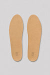 Top view of a pair of tan lambskin insoles with embossed OLEN Made in Italy logo on a light grey background