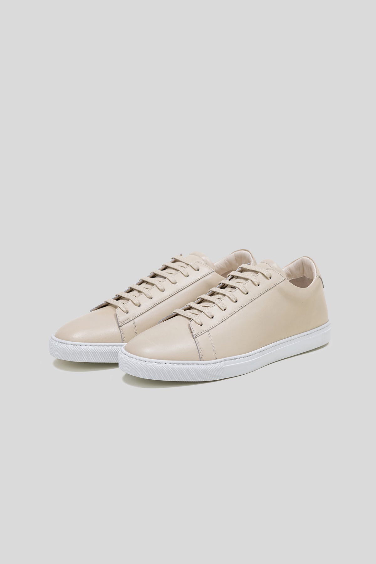 Pair of Olen beige calfskin Città sneakers with white rubber soles.