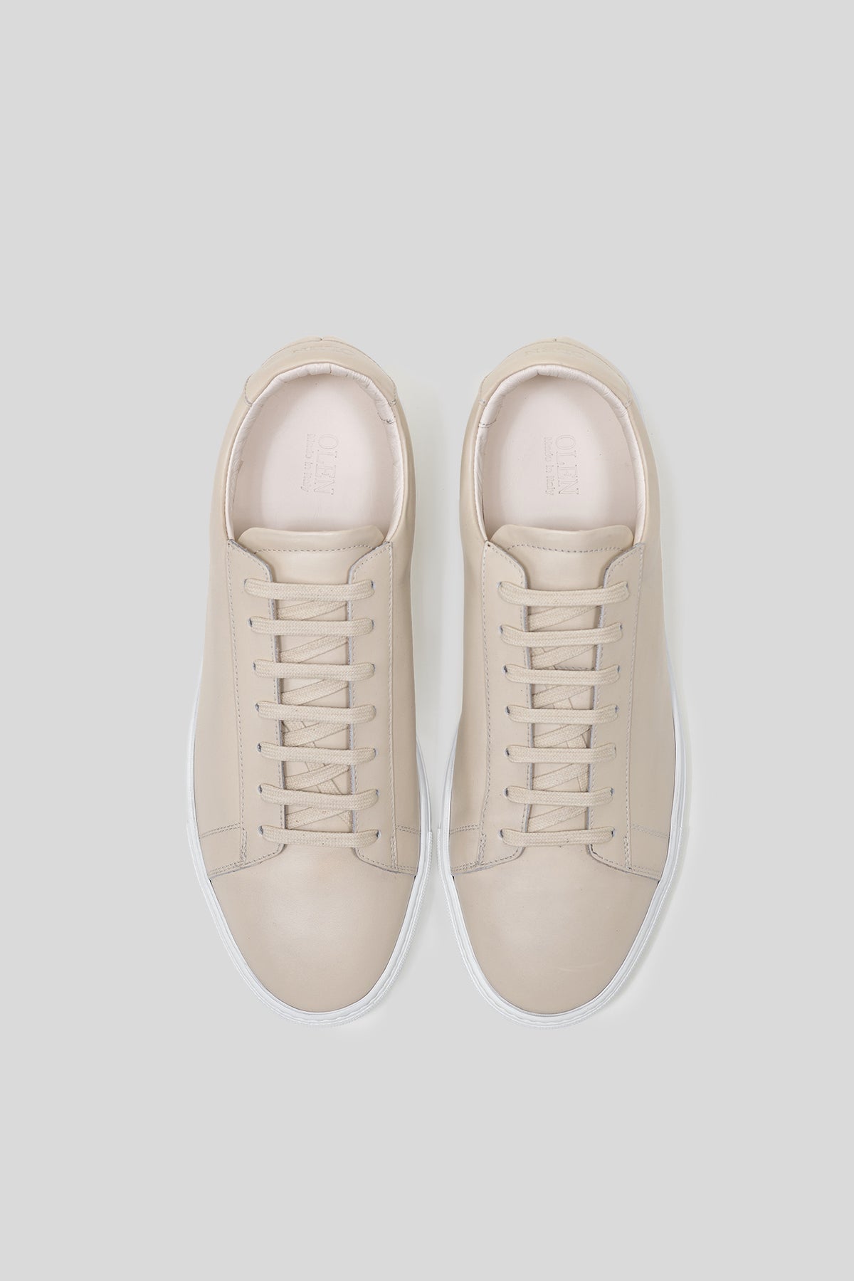 Top-down view of Olen beige calfskin Città sneakers with matching beige laces.
