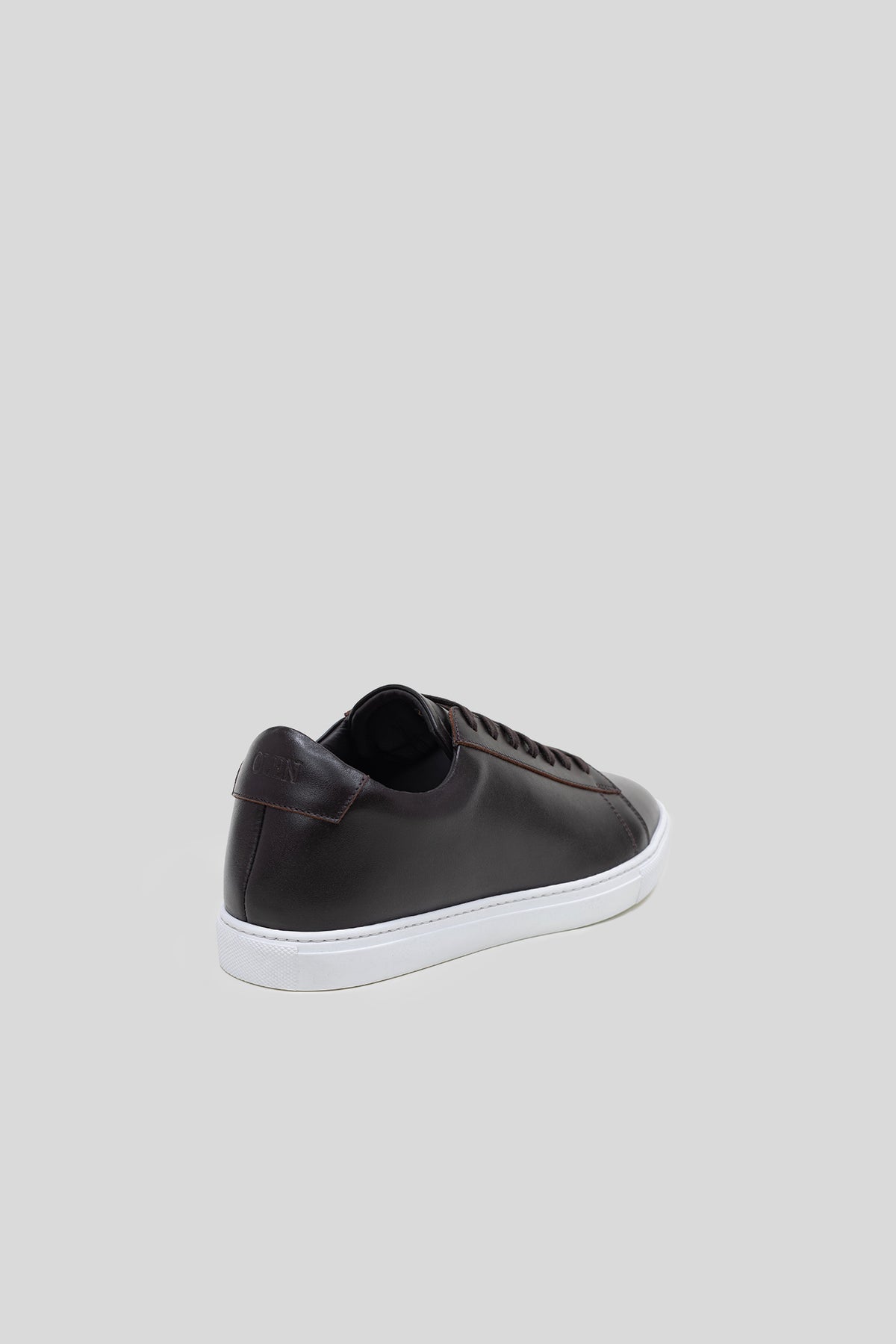 Heel view of Olen dark brown calfskin Città sneaker showing embossed logo detail.